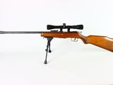 the rifle is sitting on the table with a scope on it