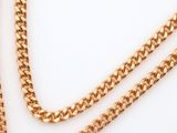 a close up of a gold chain on a white surface