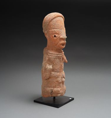 une vieille statue en argile représentant un homme coiffé d'un chapeau