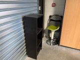 a black cabinet and a green stool in a garage
