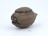 a small brown vase with a lid on a white surface