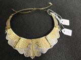 gros plan d'un collier en or sur une surface noire