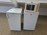 two microwaves sitting next to each other on the floor