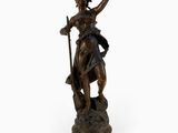 an antique bronze statue of a woman holding a staff