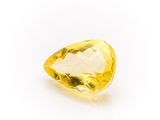 a yellow sapphire stone on a white background