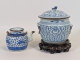 un vase bleu et blanc et une théière posés sur un socle