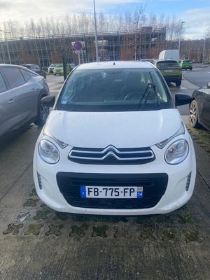 une Citrole blanche garée sur un parking à côté d'autres voitures