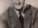 black and white photograph of a smiling man in a suit and tie