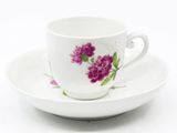 une tasse et une soucoupe blanches ornées de fleurs violettes
