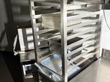 a metal rack with trays on top of it in a kitchen