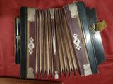 an old accordion sitting on top of a red cloth covered table