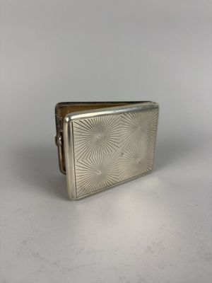 an old silver cigarette case sitting on top of a white table