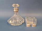 a glass decanter and four shot glasses on a table