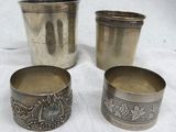trois coupes en argent ornées de motifs, posées sur une nappe blanche