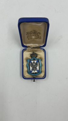 une petite boîte bleue contenant une médaille argentée et bleue