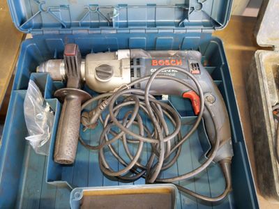 a box with a drill and other tools inside of it