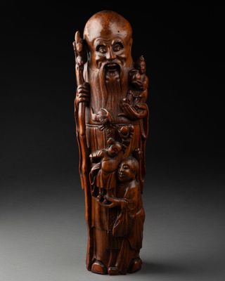 une figurine en bois sculptée représentant un homme barbu muni d'un bâton