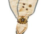 an image of a very old looking broochle with a blue and white ribbon