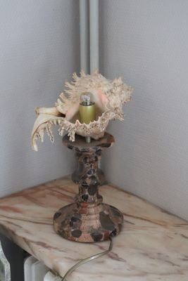 a table with a lamp and a vase with flowers on it