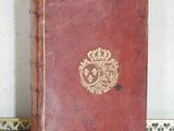 an old book with a crown on it sitting on a table