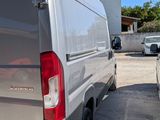 the back of a silver van parked in a parking lot