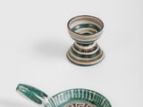 two green and white bowls and a saucer on a white surface