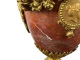 a vase with a gold decoration on it on a stand