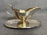 un service en argent ancien composé d'une assiette et d'une soucoupe posée dessus