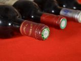 several bottles of wine are lined up on a red table