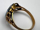 an image of a gold ring with a black stone in it