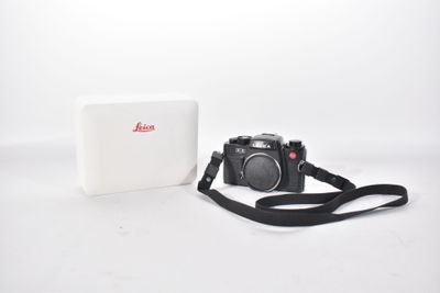 a white box with a camera on it and a black strap