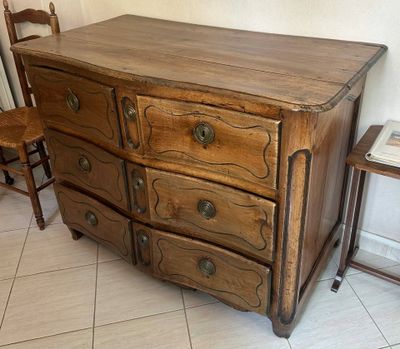 a wooden dresser and chair in a room with tile flooring