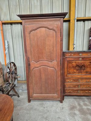 une grande armoire en bois et une commode dans une pièce