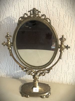 un miroir posé sur un support, lui-même posé sur une table