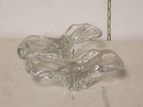 a clear glass bowl on a table with a flower in it