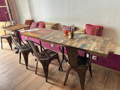 une table avec des chaises et un banc dans une pièce