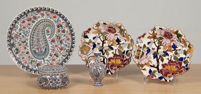 trois assiettes et un vase posés sur une table, avec un mur en arrière-plan