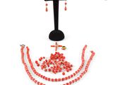a close up of a necklace and earring set on a stand
