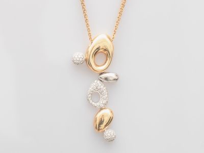 un gros plan d'un collier en or et diamants sur fond blanc