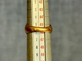 a thermometer with a gold band on top of it