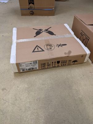 une boîte en carton posée par terre à côté d'une autre boîte en carton posée par terre