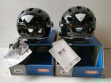 pair of black helmets sitting on top of boxes on a table