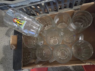 une boîte remplie de verres vides et une bouteille d'eau