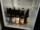 bottles of beer are sitting in a small refrigerator on a counter