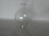 a clear glass vase sitting on a table with a white wall in the background