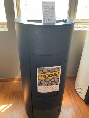 une poubelle sur laquelle est accrochée une pancarte, devant une fenêtre
