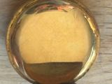 a gold pocket watch sitting on a wooden table