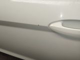 a close up of a door handle on a white car