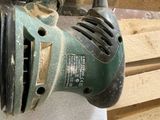 a sander that is sitting on top of a pile of wood
