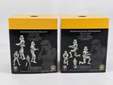 two boxes of star wars action figures sit on a white surface
